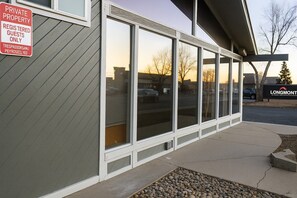 A building with a 'Private Property' sign, large windows, and a 'Longmont' sign.