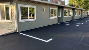 Une rangée de chambres de motel, chacune dotée de sa propre fenêtre, et un parking.