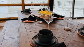 Une table à manger dressée avec des assiettes, des verres et un centre de table composé de citrons.