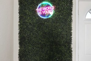 A neon sign with the text "THE WORLD IS YOURS" against a backdrop of green foliage. - KC Apt_2 BR_newly furnished and comfortable  ! (Kansas City)