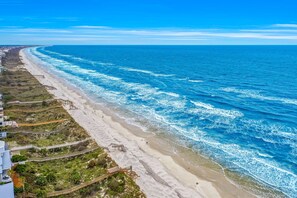 Vista sulla costa con spiaggia, oceano e una passeggiata sul mare.