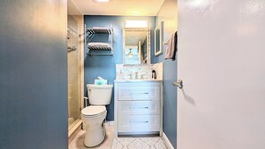 A bathroom with a toilet, sink, and a mirror. - Cool Waves Oceanfront Retreat - St Augustine Beach 2 Pools 5 Hot Tubs! On the Beach (St. Augustine)