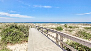 A wooden boardwalk leading to a beach with sand dunes and sparse vegetation. - Completely Renovated Oceanfront Condo W/washer/dryer & Shared Pool/tennis (Fernandina Beach)
