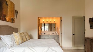Una camera da letto con un letto, una toeletta con specchio e una porta.
