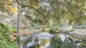 A serene pond with a fountain, surrounded by lush greenery and trees. - Amelia Island Plantation Townhome With Amazing Marsh Views, Wifi & Shared Pool (Fernandina Beach)