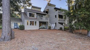 A multi-story house with a front porch, a staircase, and a small deck. - Amelia Island Plantation Townhome With Amazing Marsh Views, Wifi & Shared Pool (Fernandina Beach)