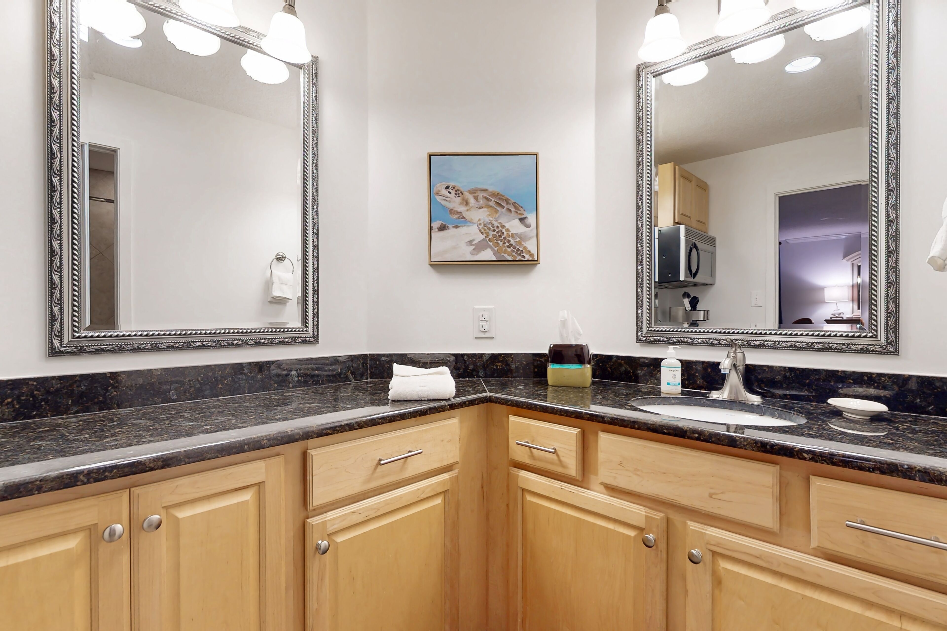 Une salle de bain avec deux grands miroirs, un lavabo et des meubles en bois.