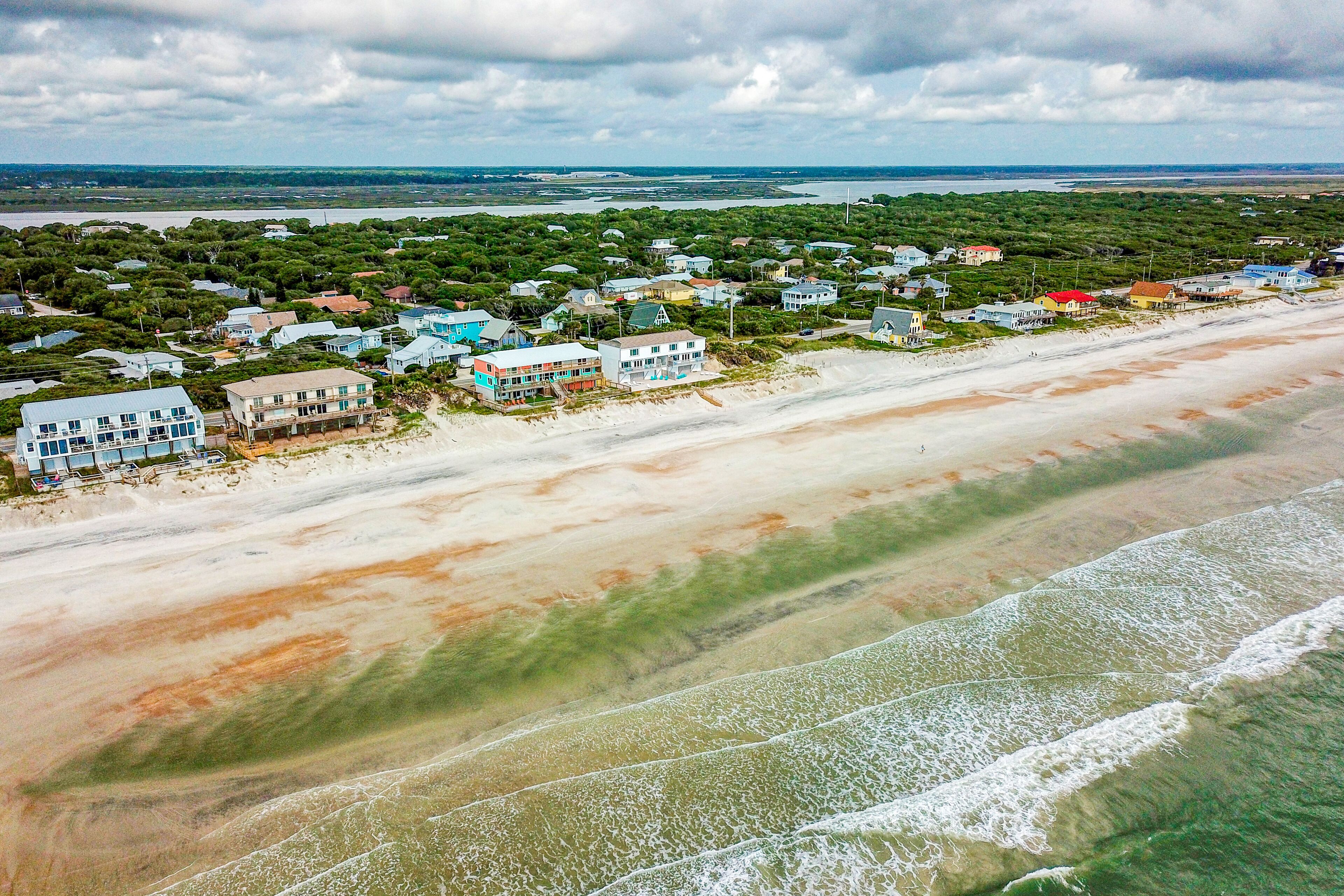 Eine Küstenstadt mit Strandhäusern, einem Sandstrand und Blick auf den Ozean.