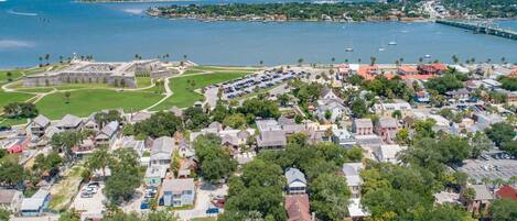 An aerial view of a coastal town with a historic fort, residential buildings, and a marina.