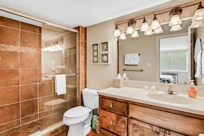 A bathroom with a glass-enclosed shower, a toilet, a vanity with a mirror, and a sink. - Charming Amelia Island Plantation Condo With Balcony, AC, Washer/dryer & Pool (Fernandina Beach)