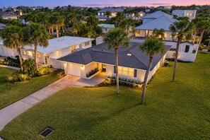 A residential area with modern houses, well-maintained lawns, and palm trees. - Beachside Snowbird Escape With Fenced Yard & Washer/dryer - Walk to Beach Access (Jacksonville Beach)