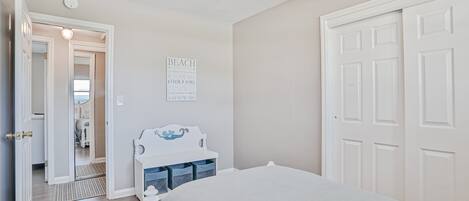 Un dormitorio con cama, cómoda, espejo y puerta.