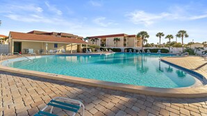 A swimming pool with lounge chairs and a building with a red roof in the background. - 3rd-floor Condo W/fountain Views, Private Balcony & W/d, On-site Pool & hot Tubs (St. Augustine)