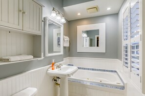 Un baño con lavamanos blanco, bañera y espejo.