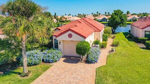 A residential area with houses, a clear sky, and a water body in the background. - Charming Home With Pool, Patio, Tennis, Central AC, & Washer/dryer (St. Augustine)