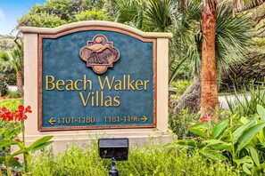 Un panneau indiquant l’emplacement de Beach Walker Villas, avec des flèches directionnelles et des numéros de téléphone.
