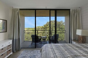 A bedroom with a large sliding glass door leading to a balcony with outdoor furniture. - 1179 Beach Walker (Fernandina Beach)