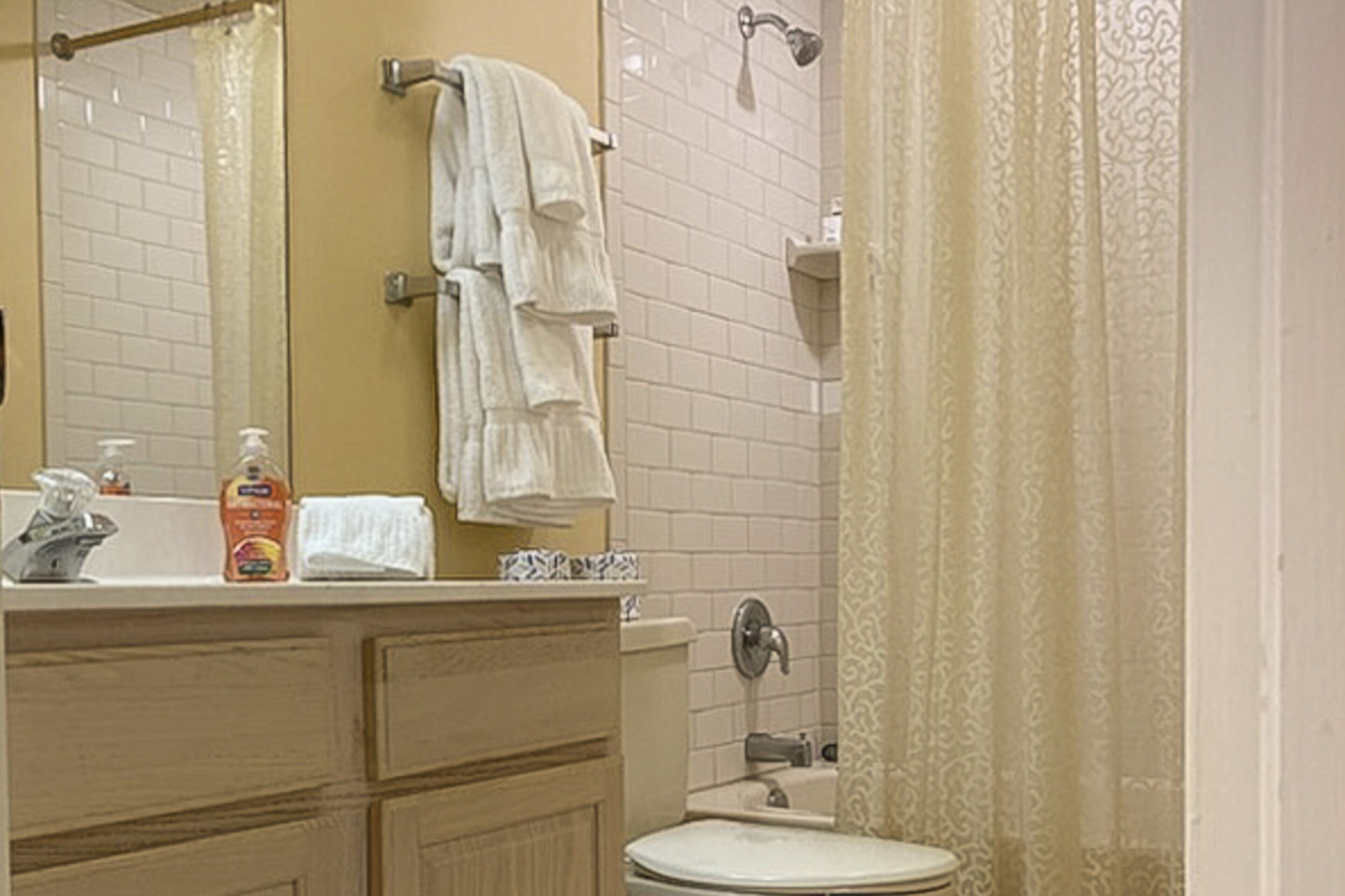 A bathroom with a toilet, sink, and a shower area.
