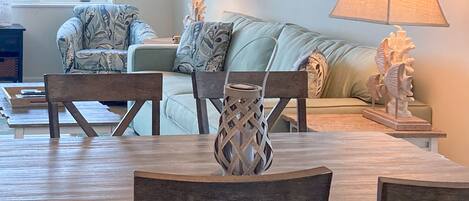 Un coin repas avec une table et des chaises en bois, un canapé et des lampes décoratives.