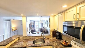 A kitchen with granite countertops, a stainless steel refrigerator, and a built-in oven. - Casatawaves Ocean View Villa Awesome Resort Pools! Trolley! (St. Augustine)