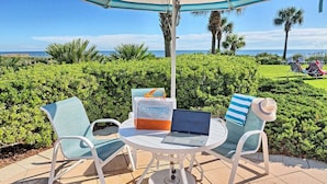A patio with two chairs, a table, and a laptop. - Coastal Breeze Luxurious Coastal Villa Steps to Cinnamon Beach Beautiful Pools! Perfect for Families (Palm Coast)