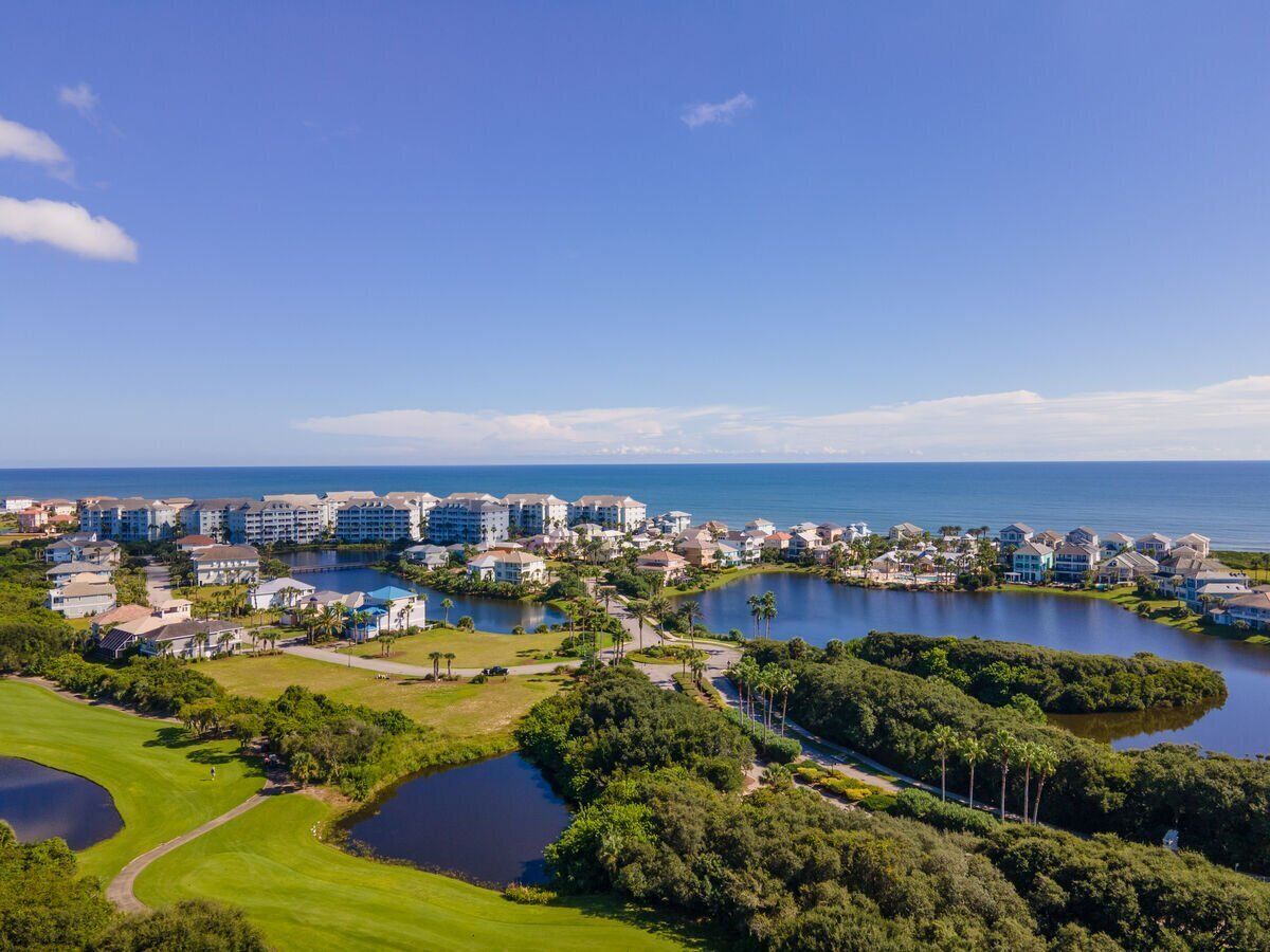 Un complex turístic a la costa amb diversos edificis, un camp de golf i diverses masses d'aigua.