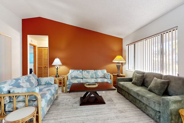 A living room with a sectional sofa, a coffee table, and two lamps. - Coastal Home Near Beach With Private Outdoor Pool, Washer/dryer, AC, & Wifi (Palm Coast)