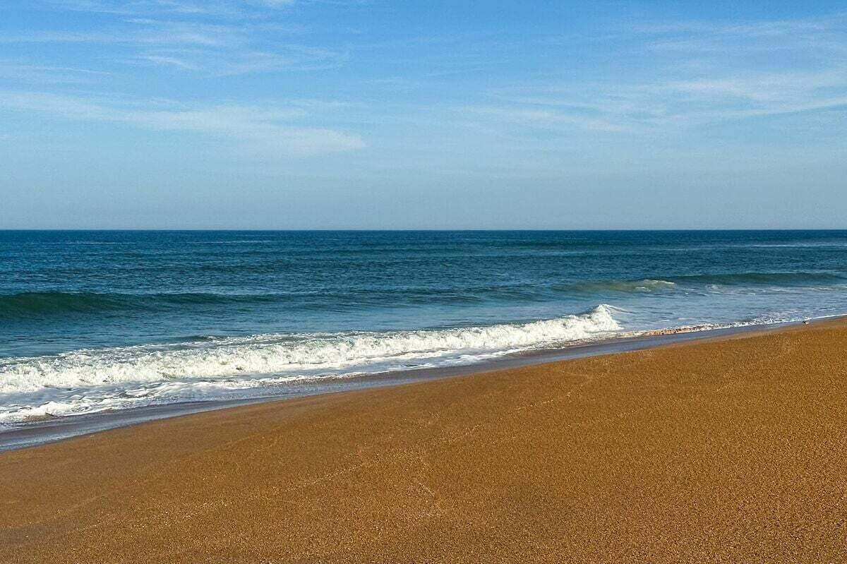 A beach with a clear sky and calm sea.
