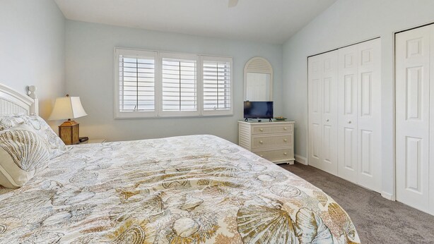 A bedroom with a bed, dresser, and wardrobe. - Beautiful Amelia Island Townhome With Pool & Tennis, Central AC (Fernandina Beach)