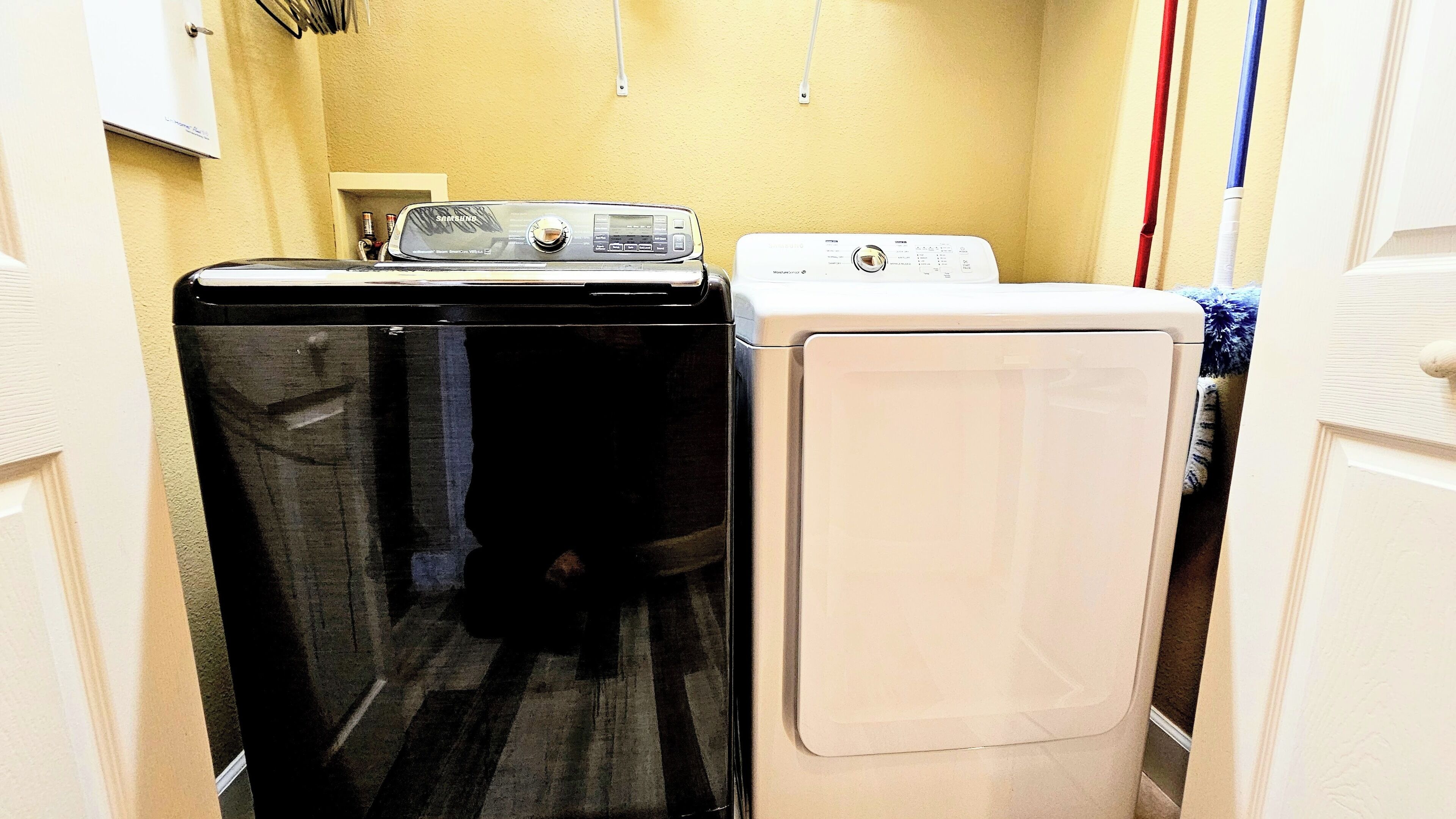 Une buanderie équipée d’une machine à laver noire et d’une machine à laver blanche.