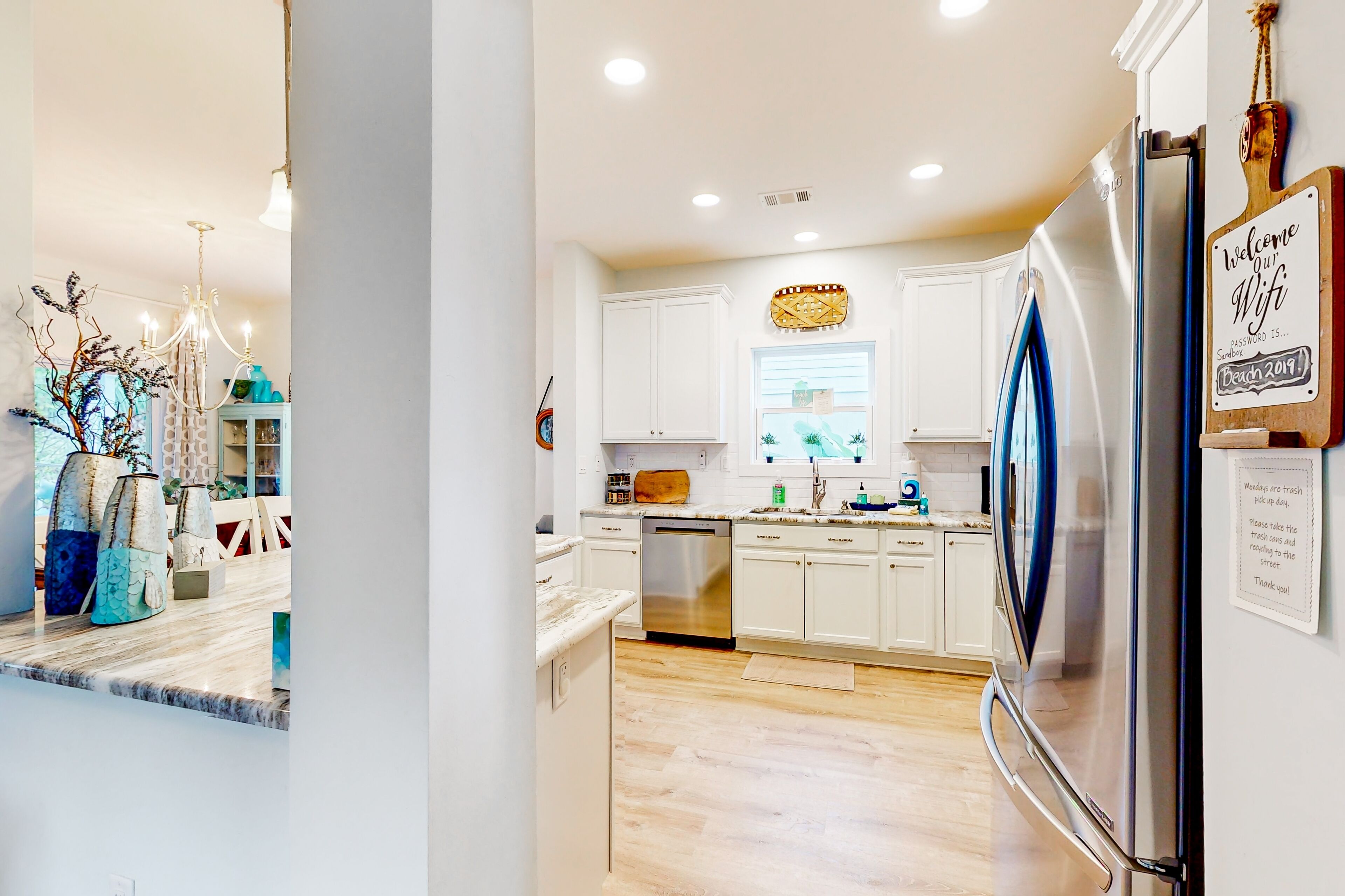 A modern kitchen with white cabinets, stainless steel appliances, and a wooden countertop.