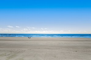 A wide, open beach with a clear sky and calm sea. - Charming Getaway w/ a Kitchenette & Free Wifi - Walk to the Beach (St. Simons Island)