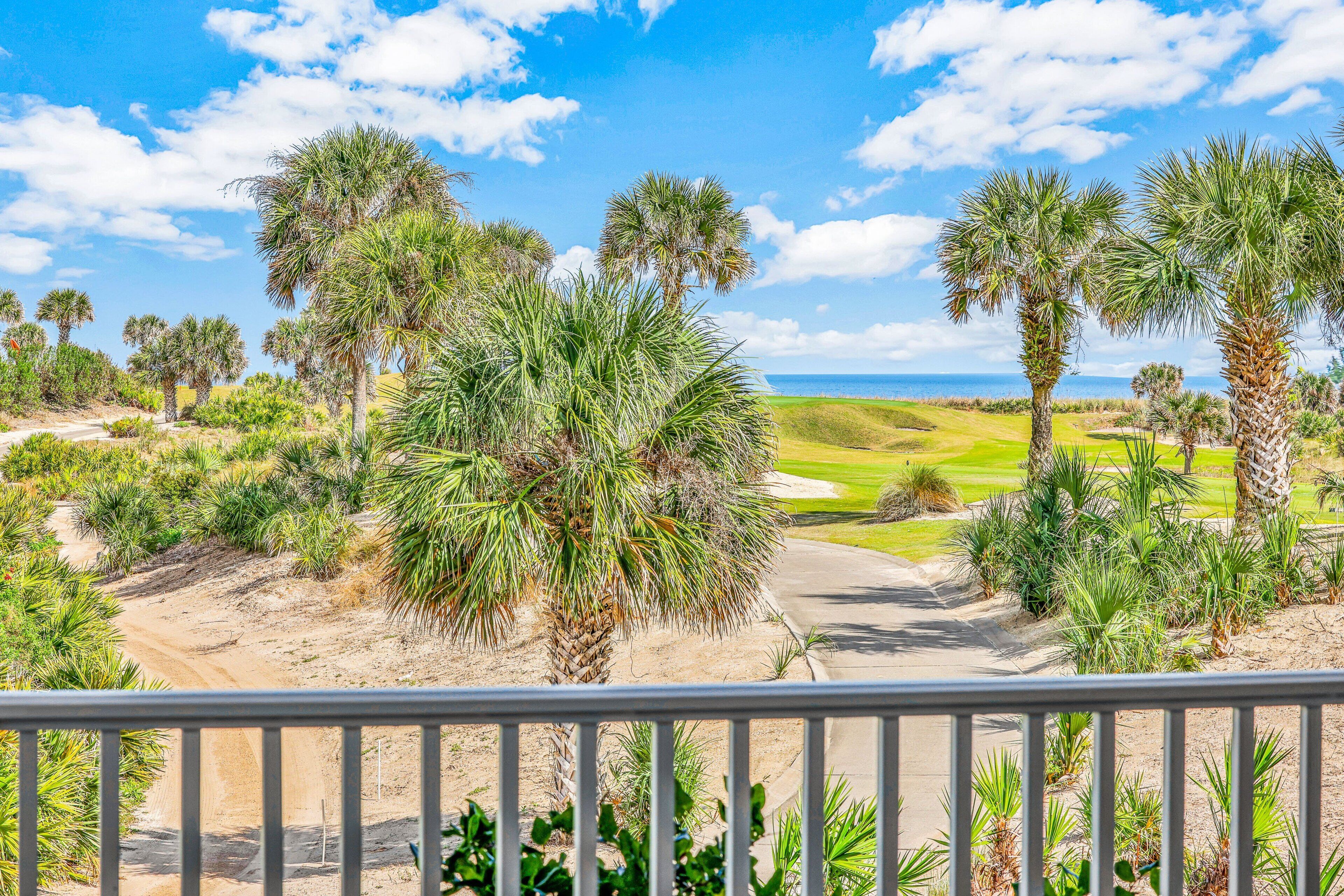 A golf course with palm trees and a clear sky.