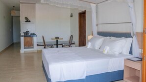 A hotel room with a bed, a small desk, a chair, and a table. - GSIH Hotel Diani (Diani Beach)