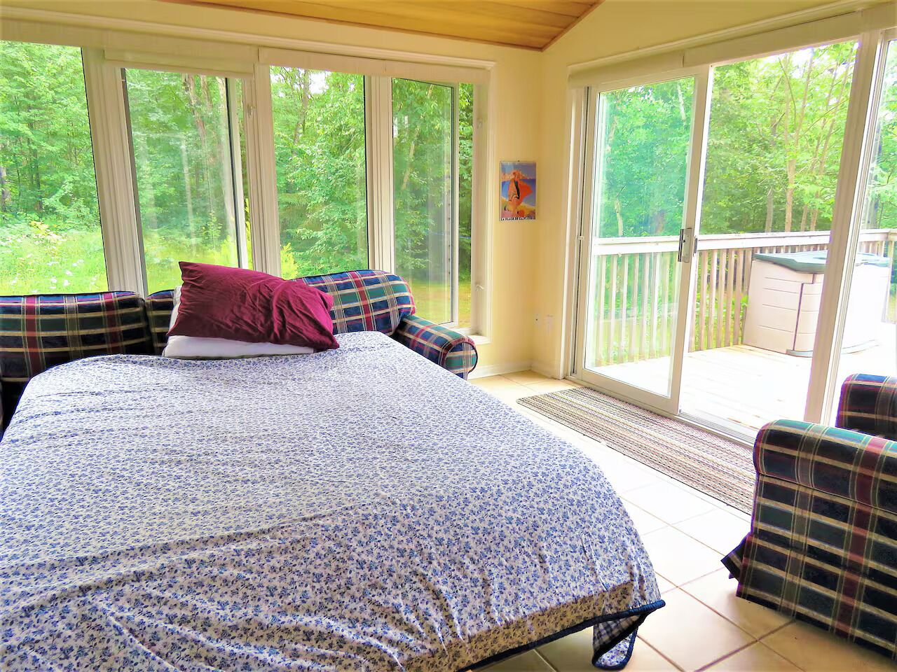 A bedroom with a large bed, a window, and a view of the outdoors.