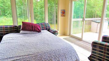 A bedroom with a large bed, a window, and a view of the outdoors.