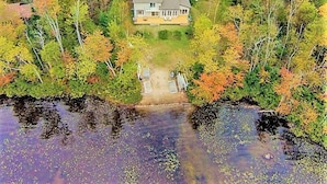An aerial view of a house surrounded by trees and a body of water. - Lakeside Memories Await at Trenanthia's Cahoots Cottage (Gravenhurst)