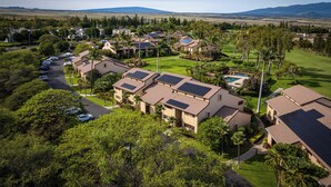 Zona residencial con varias casas, paneles solares y un campo de golf.