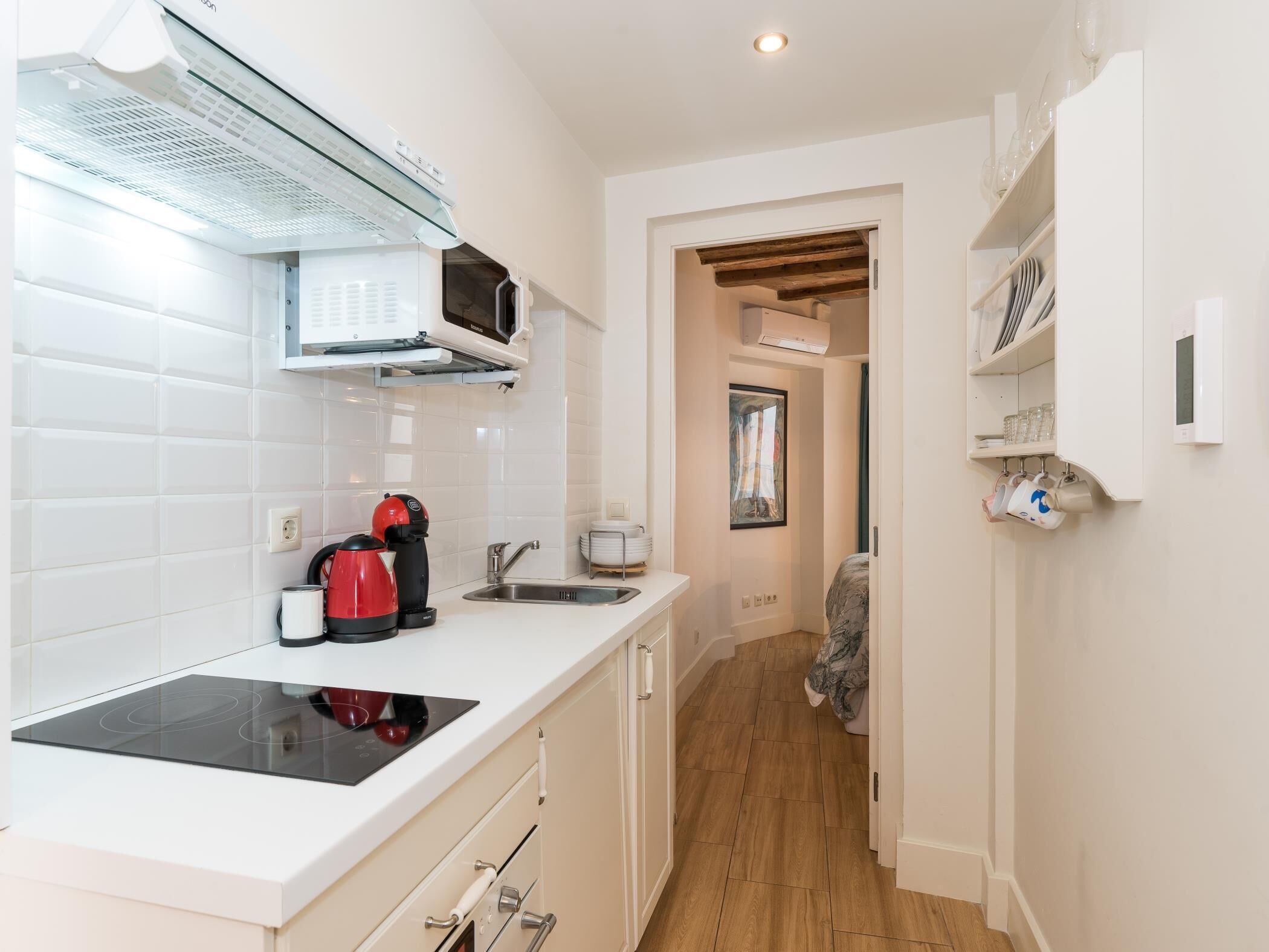 A modern kitchen with a built-in stove, a coffee maker, and a microwave.