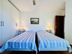 Ein Zimmer mit zwei Betten, einem Bild an der Wand und einer Tür.