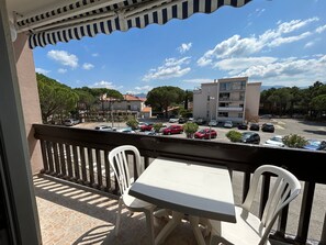 Un balcone con vista su un parcheggio e degli edifici.