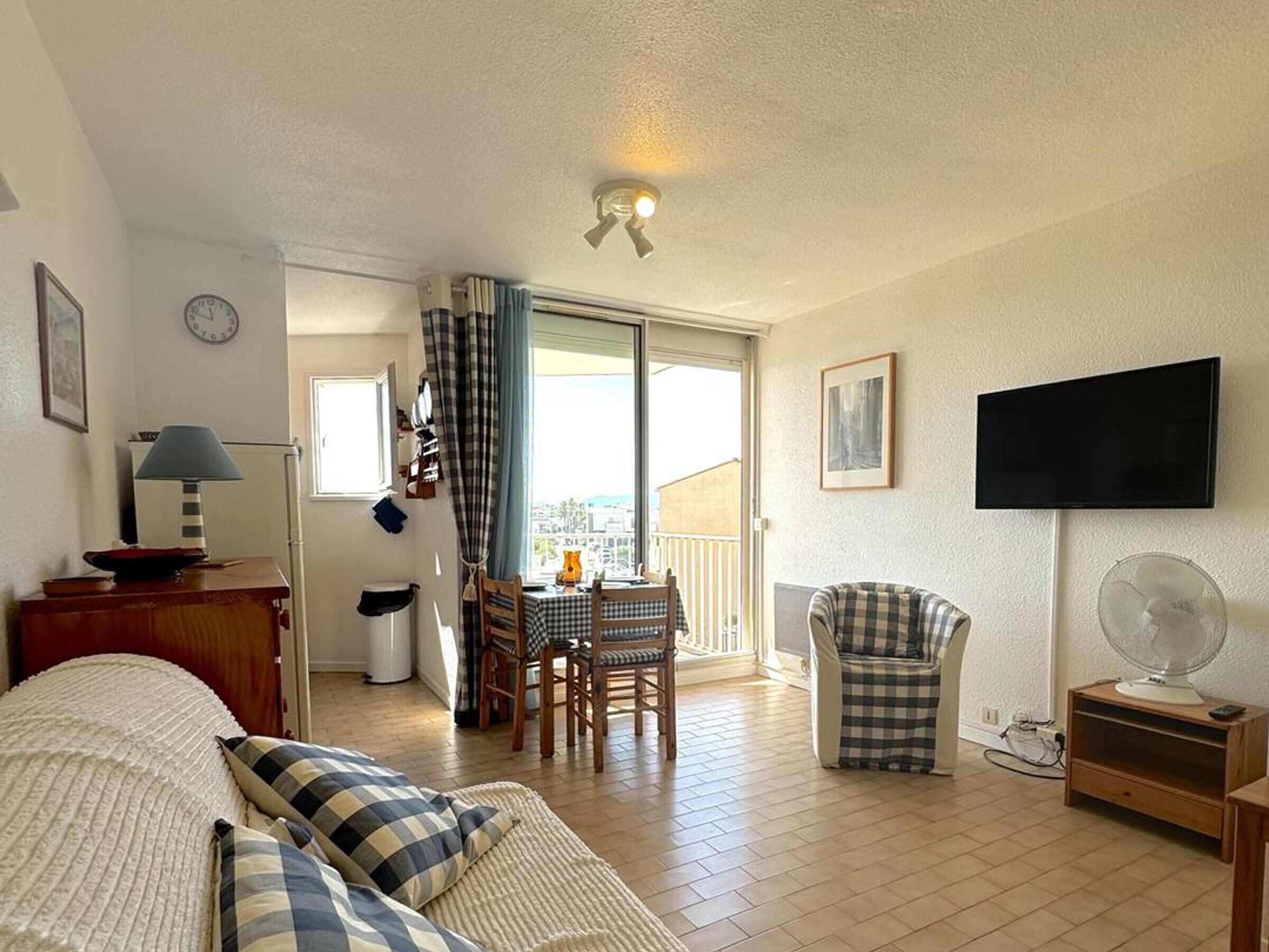 Ein gemütliches Zimmer mit Bett, Tisch mit Stühlen, Fernseher und Balkon mit Aussicht.