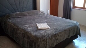 Makuuhuone, jossa on sänky, yöpöytä, puinen ovi ja ikkuna.