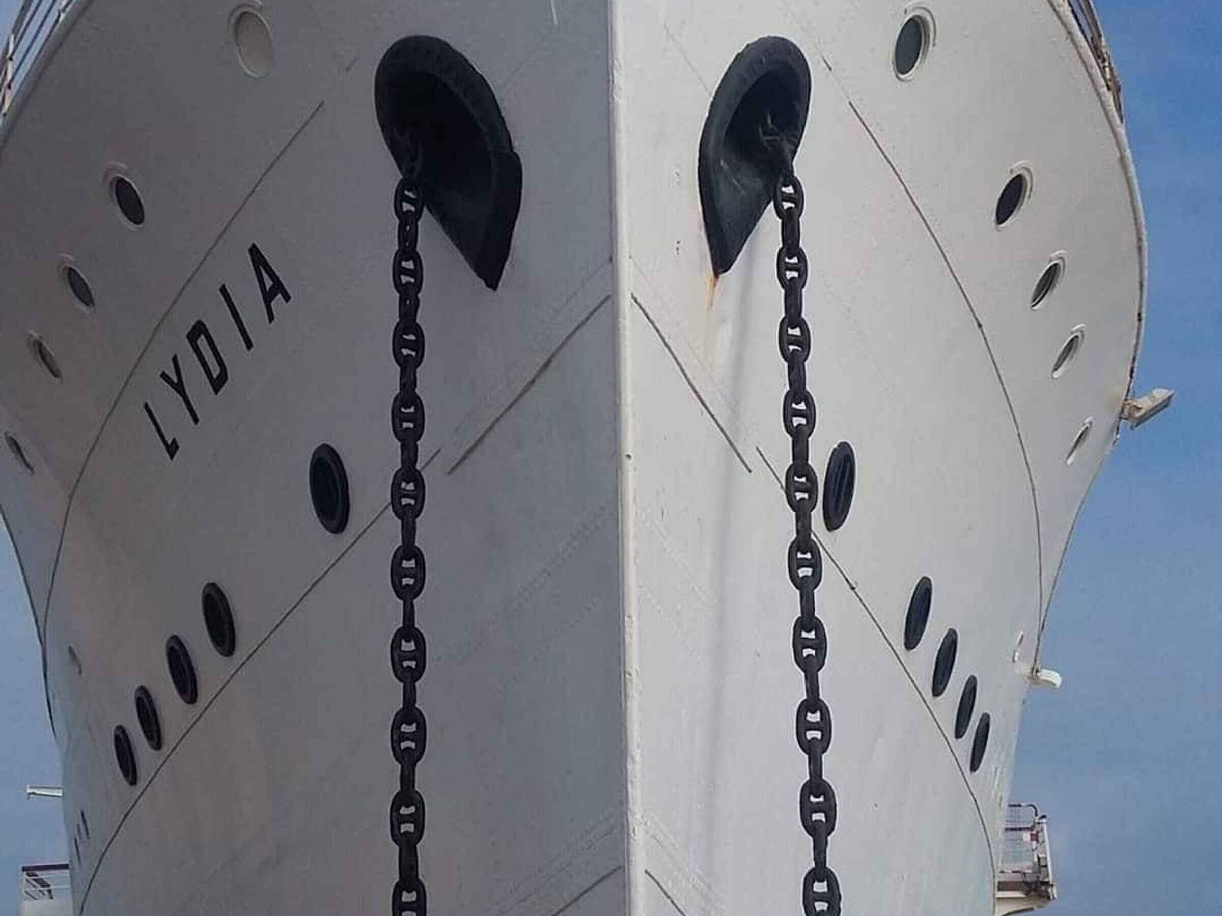 La proue d’un navire portant le nom « LYDIA » et ornée d’une série de maillons de chaîne noirs.