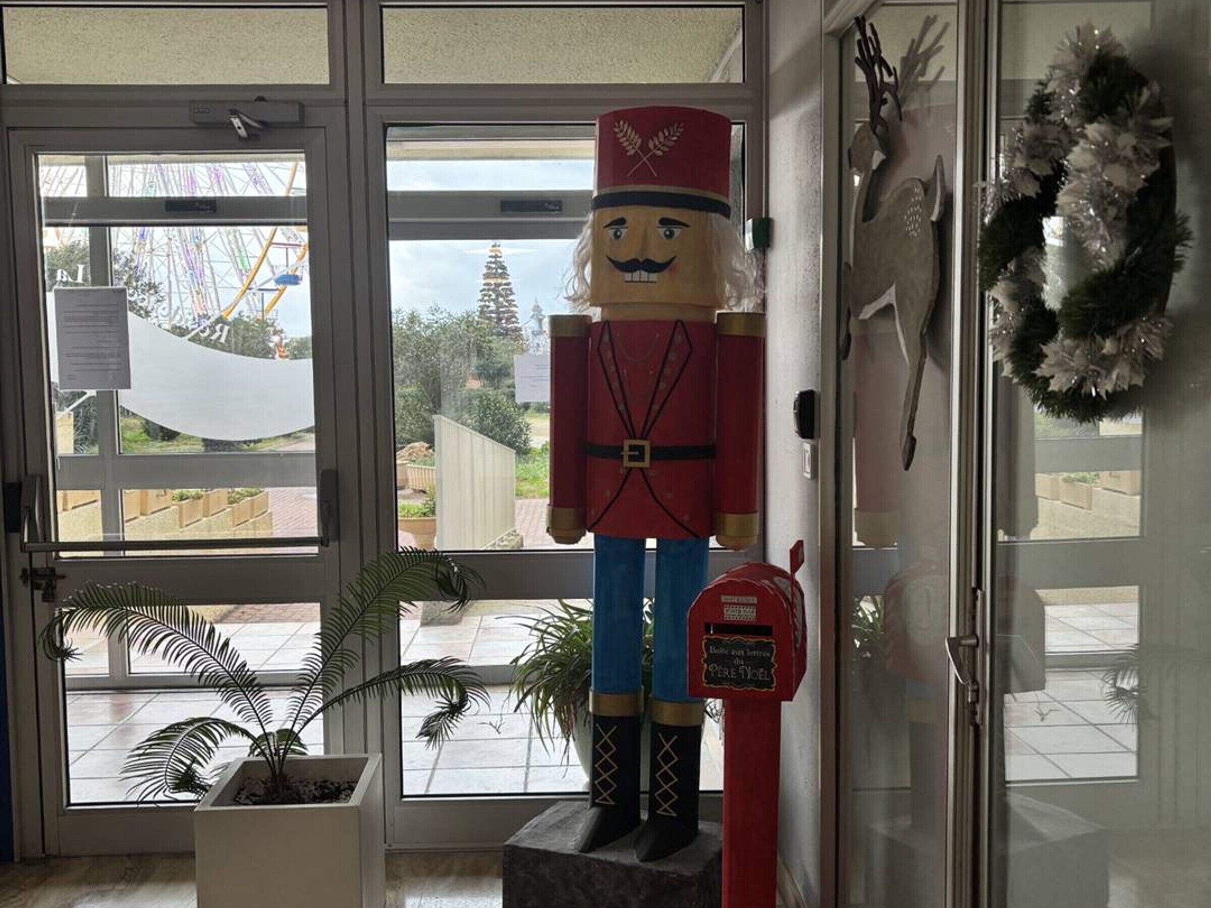 A nutcracker figure standing next to a mailbox in a doorway.