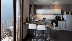 Een moderne keuken met een centraal eiland, barstoelen en uitzicht op het omliggende landschap.