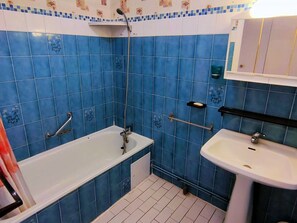 A bathroom with blue tiles, a bathtub, a sink, and a shower. - 3-room apartment with air conditioning and parking in central Canet-Plage (Canet-Plage)