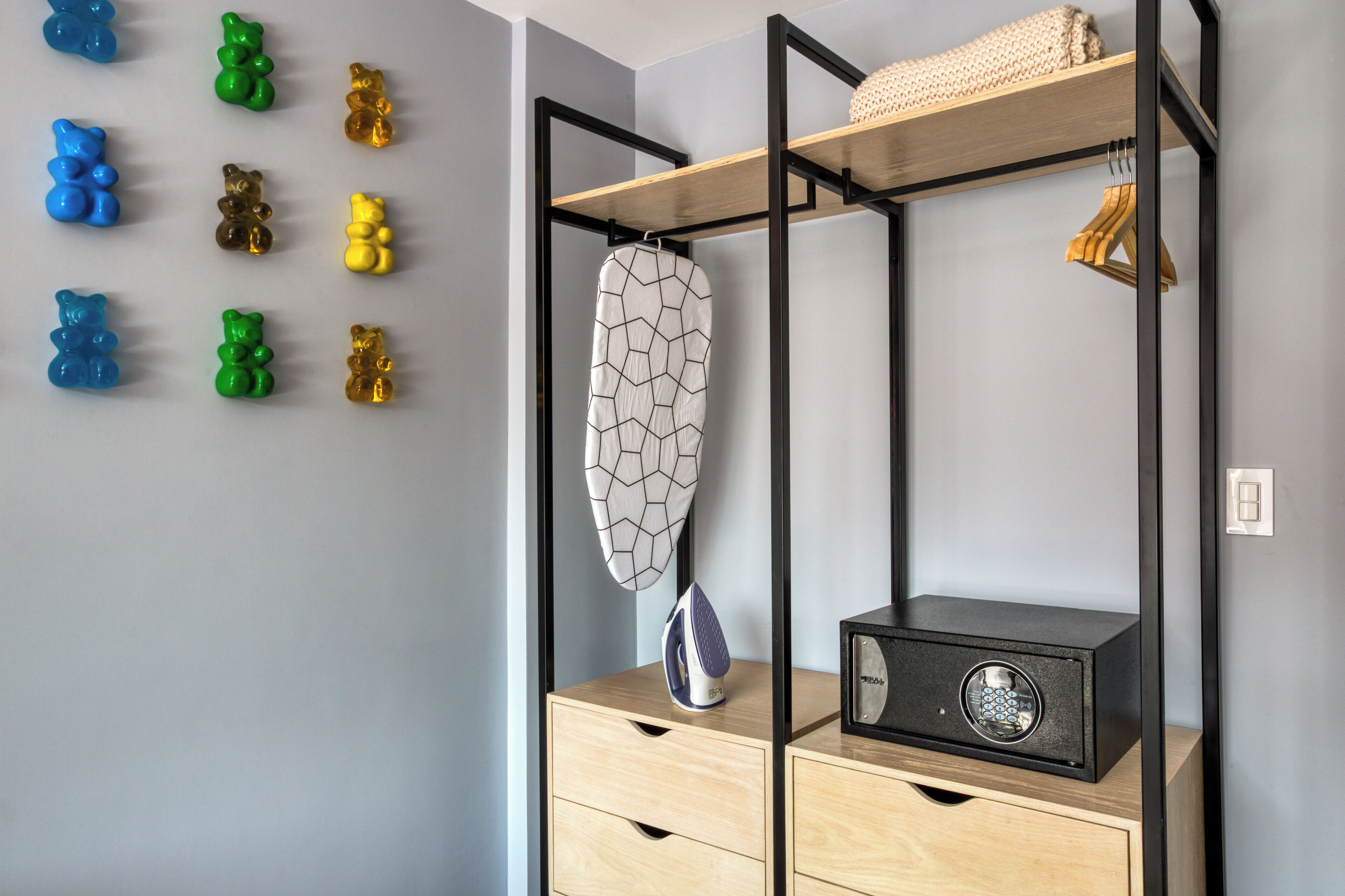 Une chambre avec un lit, une armoire, un radiateur et un mur décoré de motifs représentant des ours.