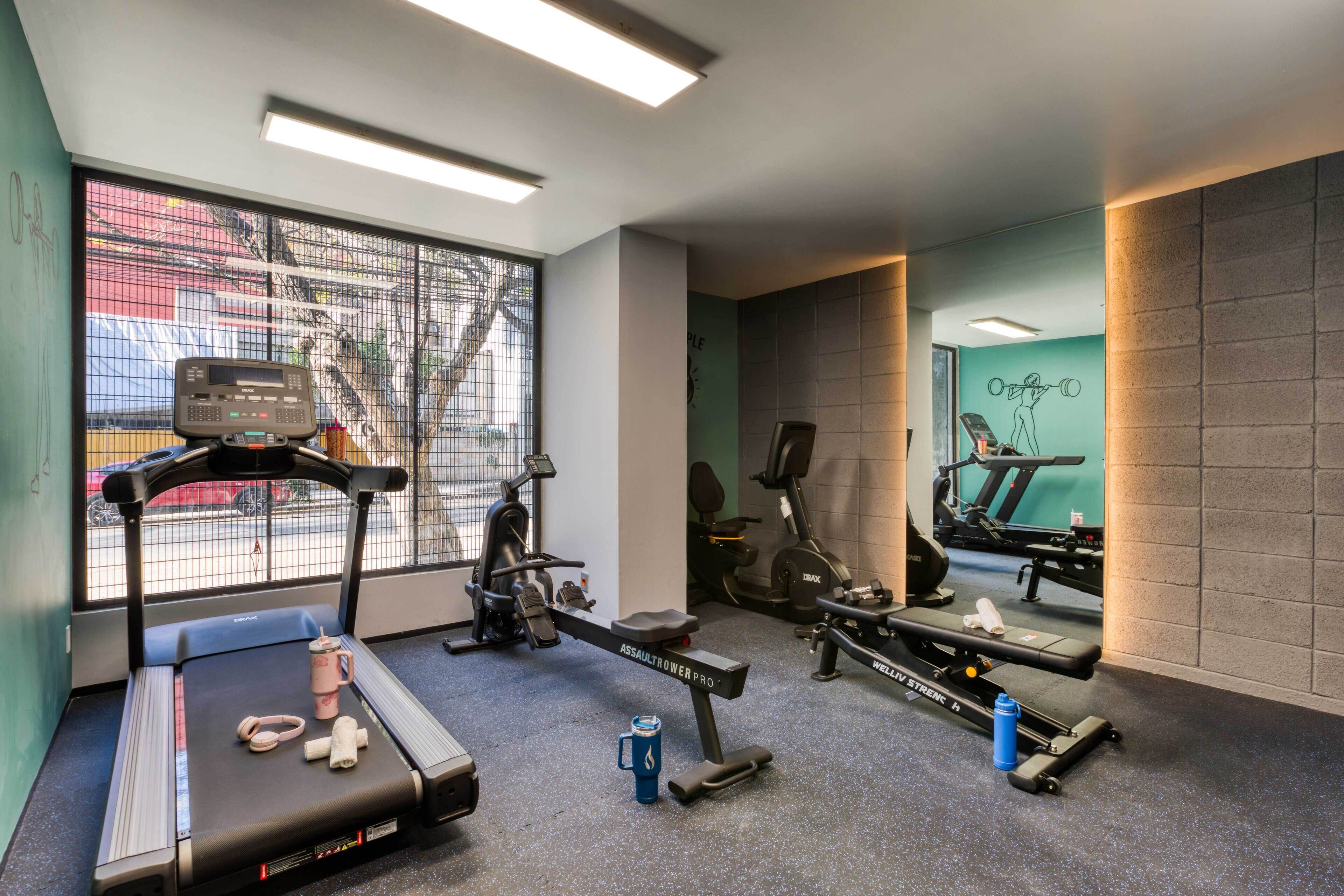 A gym with treadmills, stationary bikes, and weight machines.