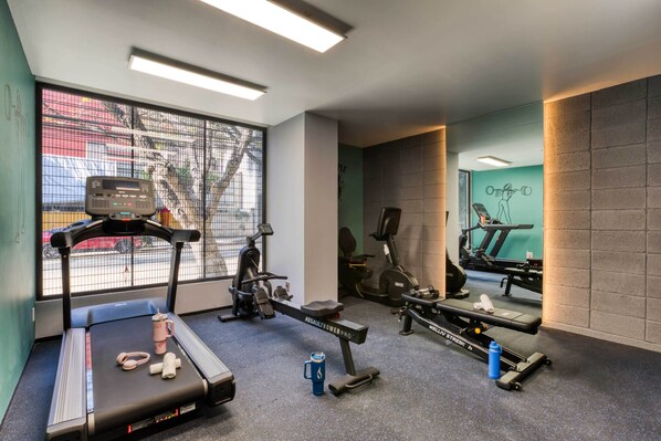 A gym with treadmills, stationary bikes, and weight machines.